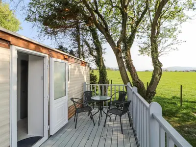 a tiny house with a table and chairs on a deck at No 29 Wyndham Hall in Cockermouth