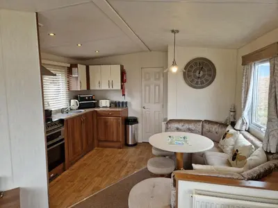 a kitchen with a couch and a table in a room at Peaceful Seaside Getaway in Mainsriddle