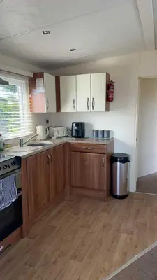 a kitchen with wooden cabinets and a counter top at Peaceful Seaside Getaway in Mainsriddle