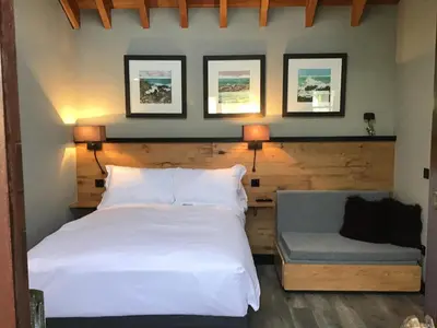 a bedroom with a white bed and a couch at Lightkeepers Snug in Portpatrick