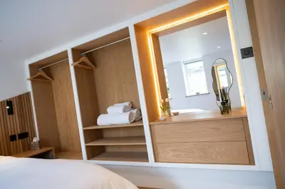 a bedroom with a mirror and a sink and a bed at Tucked Away in Keswick