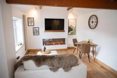 a living room with a couch and a fireplace at Tucked Away in Keswick