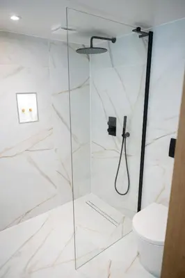 a bathroom with a shower with a toilet at Tucked Away in Keswick
