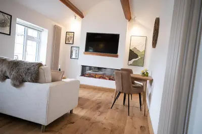 a living room with a couch and a table and a fireplace at Tucked Away in Keswick