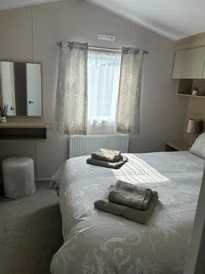 a bedroom with a bed with two towels on it at One Muirfield, Caravan at Turnberry in Turnberry