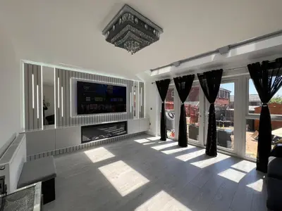 a living room with a tv and some windows at Z&Z Villa in Moffat