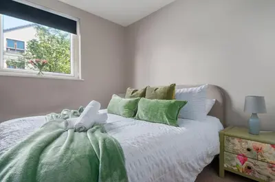 a white bedroom with a bed with a window at The Cozy Atmosphere Lodge in Moffat