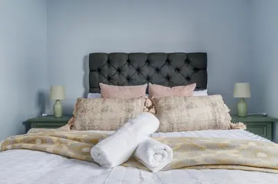 a bed with a blanket and pillows on it at The Cozy Atmosphere Lodge in Moffat