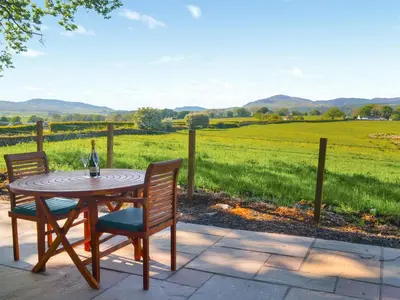 a table and chairs with a view of a field at The Shepherd's Rest in Auchencairn