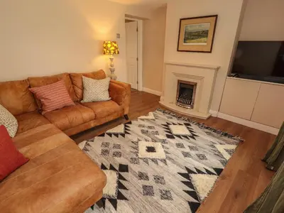 a living room with a couch and a fireplace at Kirkland Howe Cottage in Frizington