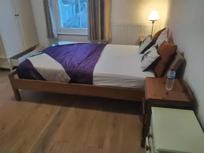a bed in a small room with a bottle on a table at 98 Board street in Moffat