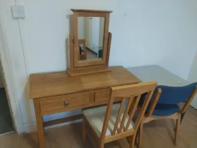 a wooden dressing table with a mirror and a chair at 98 Board street in Moffat