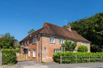 an old brick house with a fence in front of it at Beautiful 3 bedroom cottage close to Goodwood ! in Moffat