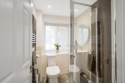 a bathroom with a toilet and a sink and a shower at Beautiful 3 bedroom cottage close to Goodwood ! in Moffat