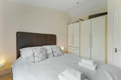 a bedroom with a white bed with towels on it at Troutbeck Lodge in Bassenthwaite