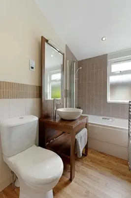 a bathroom with a toilet and a sink and a tub at Troutbeck Lodge in Bassenthwaite
