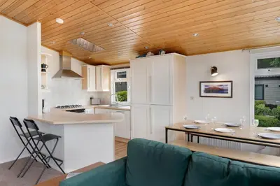 a kitchen and living room with a wooden ceiling at Troutbeck Lodge in Bassenthwaite