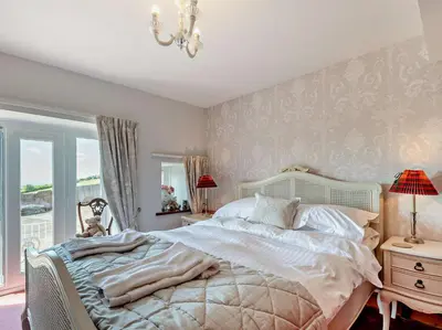 a bedroom with a large bed and a chandelier at 2 Bed in Ireby 96088 in Ireby