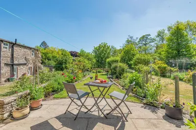 a patio with a table and chairs in a garden at 2 Bed in Caldbeck oc-a32049 in Caldbeck