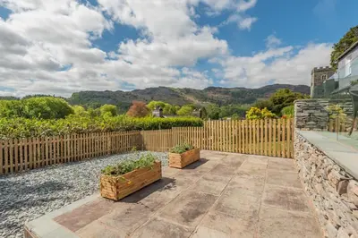 a backyard with two potted plants and a wooden fence at 2 Bed in Chapel Stile oc-u32104 in Chapel Stile
