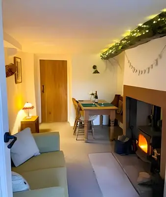 a living room with a table and a fireplace at Cozy Cottage in Caldbeck in Caldbeck