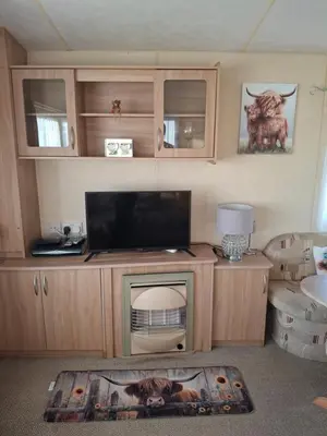 a living room with a flat screen tv on a stand at The Coo Shed 94 in Newton Stewart