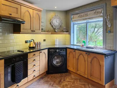 a kitchen with a washer and dryer in it at Upper Double Lodge in Kirkcudbright