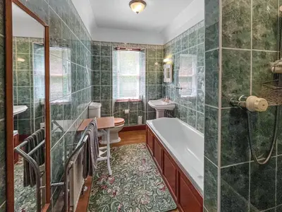 a bathroom with a tub and a toilet and a sink at Upper Double Lodge in Kirkcudbright