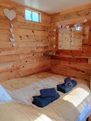 a bedroom with a bed with two blue towels on it at The Box in Moffat