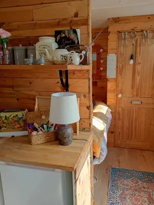 a room with a table with a lamp on it at The Box in Moffat