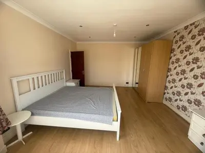 a bedroom with a white bed and a wooden floor at Harrow Inn Rooms in Yarrow