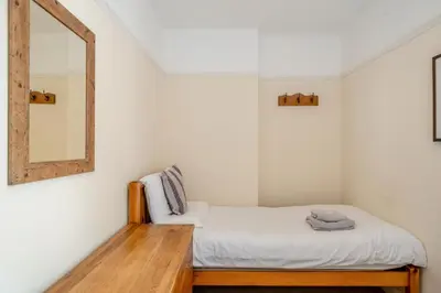 a small bedroom with a bed and a mirror at 3 Bed in Ravenglass oc-e32106 in Ravenglass