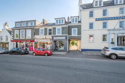 a street with cars parked in front of buildings at 2 Bed in Moffat oc-a32121 in Moffat