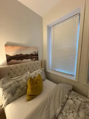 a bedroom with a bed with a yellow pillow on it at Cosy Double Bedroom in Little Venice, Maide Vale in Moffat