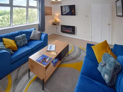 a living room with blue couches and a coffee table at Station House in St Bees