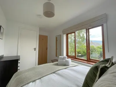 a bedroom with a bed with a large window at Mill House in Braithwaite