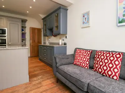 a living room with a couch and a kitchen at Sunnycroft in Keswick
