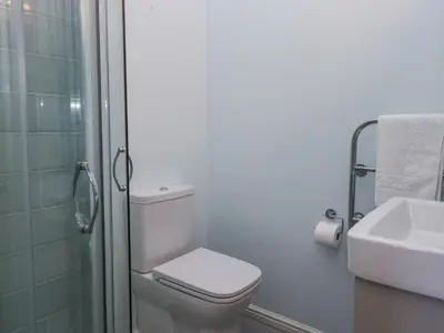 a white bathroom with a toilet and a sink at Sunnycroft in Keswick