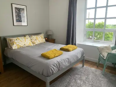 a bed with two yellow pillows on it in a bedroom at Unique schoolhouse in the peaceful Western Lakes in Bootle
