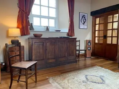 a living room with a wooden cabinet and a window at Unique schoolhouse in the peaceful Western Lakes in Bootle