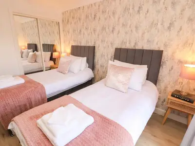 two beds in a room with two mirrors at The Paddock in Kirkcowan