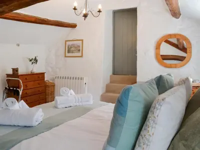 a bedroom with a large bed in a room at Rattlebeck Cottage in Glenridding