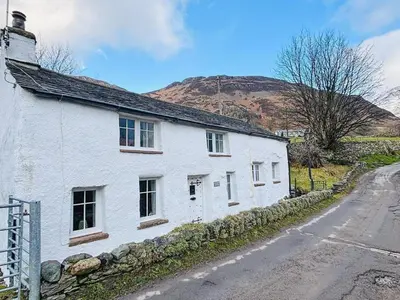 a white house on the side of a road at Rattlebeck Cottage in Glenridding