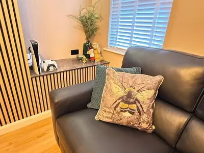 a black leather couch with a pillow on it at Modern House Maryport Sleeps 6 in Maryport