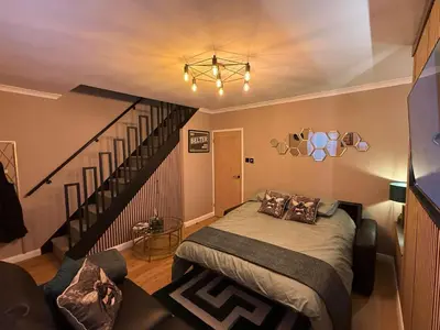 a bedroom with a bed and a stair case at Modern House Maryport Sleeps 6 in Maryport