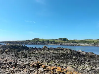 a group of rocks on the shore of a body of water at Ninians Landing in Kirkcudbright