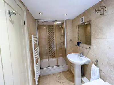 a bathroom with a sink and a shower at Old Corner Barn Lake District Escape by PolkaStays in Penrith