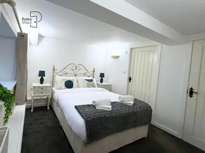 a bedroom with a large white bed with two towels on it at Old Corner Barn Lake District Escape by PolkaStays in Penrith