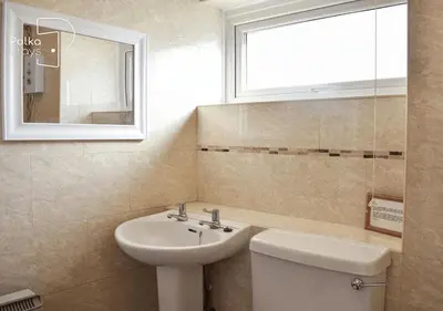 a bathroom with a sink and a toilet and a window at Crag Barn Cottage Lake District by PolkaStays in Penrith