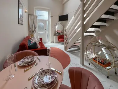 a dining room with a table and chairs and stairs at Three Chapel Court in Cockermouth